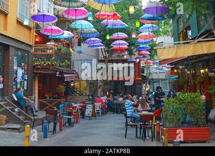 Istanbul, Türkei - 18. September 2019. Bunte Sonnenschirme hängen vom Himmel und überdecken eine Straße mit Bars und Restaurants im Moda Viertel Kadikoy Stockfoto