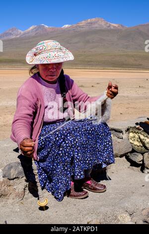 Peruanische Frau spinnende Wolle mit traditioneller gestickter Mütze, Colca Canyon, Salinas und Aguada Blanca National Reserve, Andenplateau Peru Stockfoto