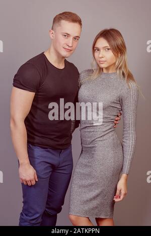 Vertikales Porträt eines jungen Ehepaares kaukasischer Ethnie. Weißer Mann und Frau posieren für Foto. Ein muskulöses Männchen und ein schlankes elegantes Weibchen Stockfoto