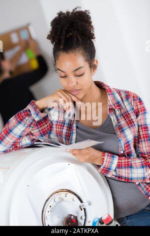 Weibliche Klempner Arbeiten an zentralen Heizkessel Stockfoto
