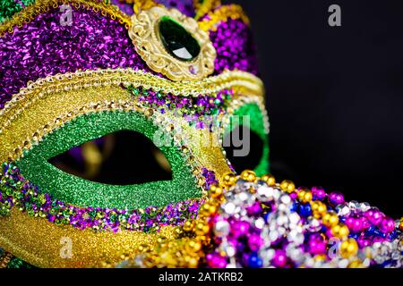 Nahansicht einer Jester-Maske mit farbigen Perlen, die im Vordergrund verschwommen sind. Schwarzer Hintergrund. Stockfoto