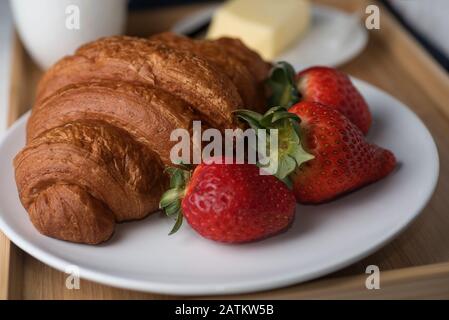 Croissant mit frischen Erdbeeren und Kaffee Stockfoto