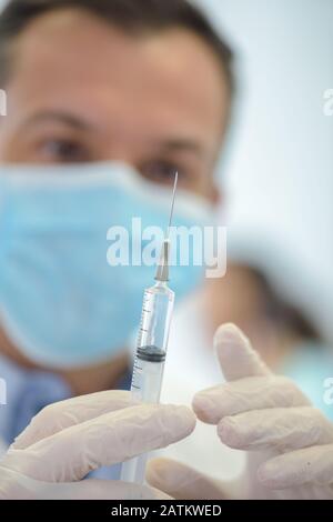 Mans-Hand in medizinischen Handschuh mit Spritze Stockfoto