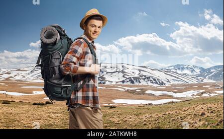 Junger Kerl, der mit einem Rucksack auf dem Berg Shara mit Schnee, Mazedonien, wandert Stockfoto