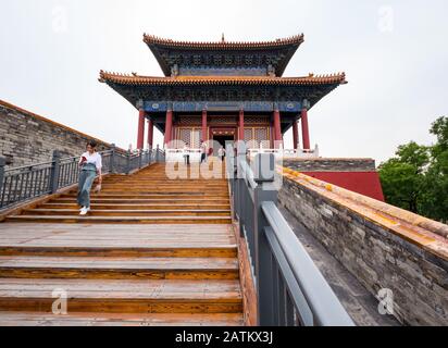 Asiatische Frau, die auf ein Handy blickt, das die Stufen hinunter geht, East Prosperity Gate, Inner Court, Forbidden City, Peking, China Stockfoto