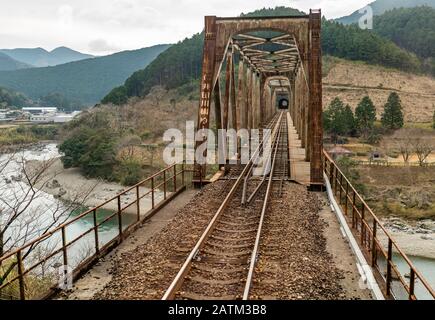 Blick auf eine Brücke über den Fluss Shimanto von einer Shikoku-Eisenbahngesellschaft (JR Shikoku), die auf der Yodo-Linie in der Präfektur Kochi, Japan, verkehrt. Stockfoto