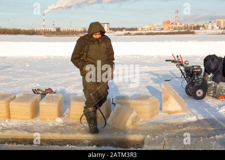 Der Monteur mit Stahlzange zieht den Eisblock heraus Stockfoto