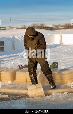 Der Monteur mit Stahlzange zieht den Eisblock heraus Stockfoto