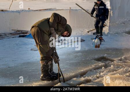 Der Monteur mit Stahlzange zieht den Eisblock heraus Stockfoto