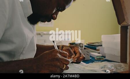 Melsisi, Pentecost Island / Vanuatu - 10. Mai 2019: Örtlicher Dorfmediziner sortiert Impfpapiere in der ländlichen Krankenhausklinik aus Stockfoto