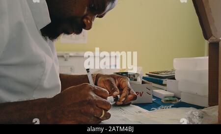 Melsisi, Pentecost Island / Vanuatu - 10. Mai 2019: Örtlicher Dorfmediziner sortiert Impfpapiere in der ländlichen Krankenhausklinik aus Stockfoto