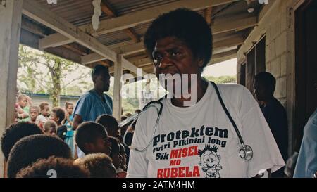 Melsisi, Pentecost Island / Vanuatu - 10. Mai 2019: Schwarze Frau medizinische Krankenschwester Doktor, die mit Kindern arbeitet, Schüler im ländlichen Dorf Stockfoto