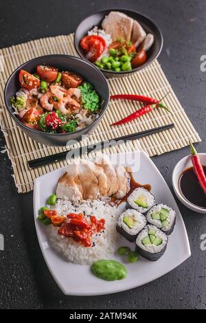Chinesische und vietnamesische Küche in vertikaler Aufnahme. Verschiedene asiatische Gerichte auf grauem Hintergrund Stockfoto