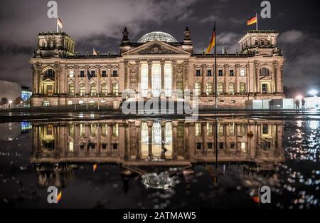 Berlin, Deutschland. Februar 2020. Das Gebäude des Reichstags spiegelt sich in einer Pfütze wider. Credit: Britta Pedersen / dpa-Zentralbild / dpa / Alamy Live News Stockfoto