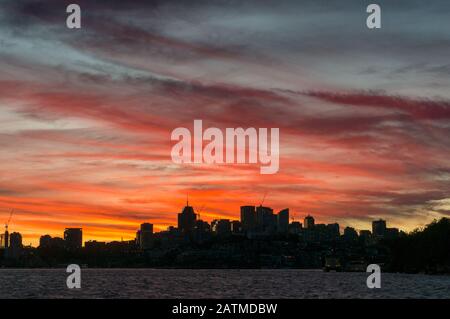 Städtisches Stadtbild mit Gebäuden am Wasser und wunderschönem Himmel bei Sonnenuntergang. Hintergrund der Vororte von Sydney, Kirribilli Stockfoto