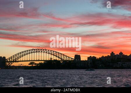 Wahrzeichen der Sydney Harbour Bridge gegen den farbenfrohen Himmel bei Sonnenuntergang. Dunkle Silhouette der Sydney Harbour Bridge das beliebte australische Reiseziel Stockfoto