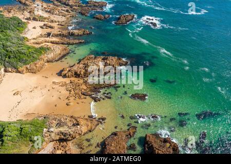 Blick von oben auf den malerischen Strand mit klarem türkisfarbenem Wasser und gelbem Sand. Tropischer Hintergrund Stockfoto