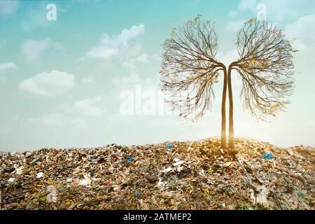 Der Lungenbaum wächst zwischen den Bergen von Trash. In der unechten surrealen Umwelt Müll Natur Umweltverschmutzung Ökologie. Umweltkonzept Stockfoto