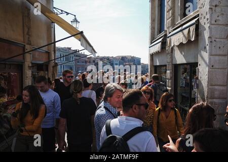 Touristenmassen von Venedig versammeln sich auf der Rialto-Brücke mit Blick auf den Markusplatz, um einzukaufen und den Blick auf den großen Kanal zu genießen. Stockfoto