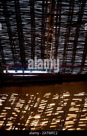 Sonnenlicht fällt durch das gewebte Korbdach eines gedeckten Marktes in der Medina von Marrakesch, Marokko Stockfoto