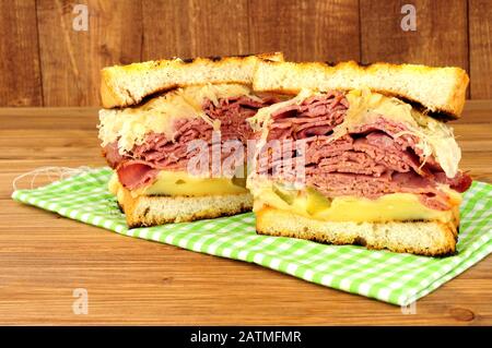 Sandwich im Pastrami-Reuben-Stil mit Sauerkraut und Schweizer Käse auf Holzgrund Stockfoto