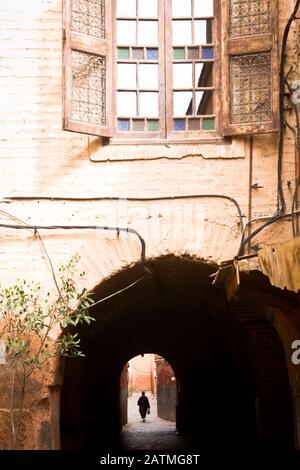 Eine Silhouettenfigur wandert auf einer Gasse in der Medina von Marrakesch, Marokko Stockfoto