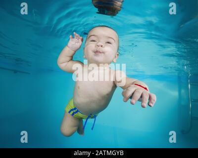 Junge lernt, unter Wasser in einem Schwimmbad zu tauchen