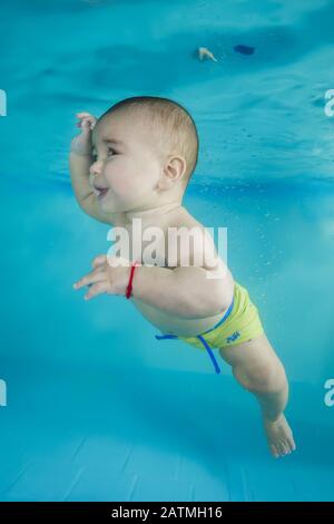 Junge lernt, unter Wasser in einem Schwimmbad zu tauchen