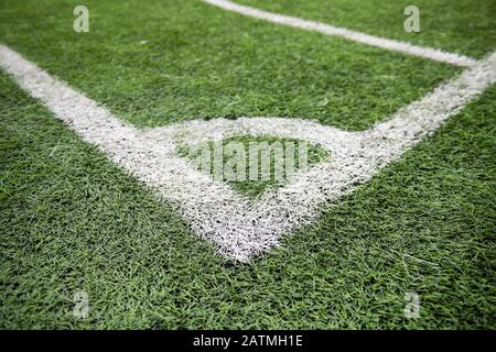 Fußball-Feldecke mit weißen Markierungen, grüne Kunstrasentextur im Fußballstadion. Stockfoto