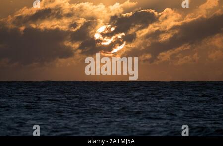 Die Sonne über Boscombe Strand in Dorset. Stockfoto