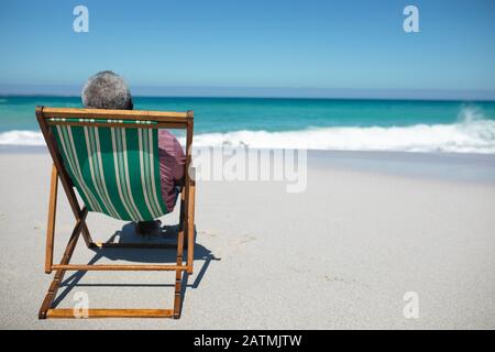 Der alte Mann erholt sich am Strand Stockfoto