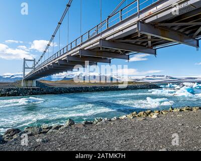 Brücke über den Jokulsarlon-Gletscher und Eisberge, die im Fluss schweben, einer der touristischsten Orte in Island. Stockfoto