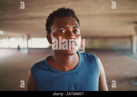 Portrait eines schwitzenden, ernsthaften jungen, athletischen afroamerikanischen Mannes, der im Freien auf der Suche nach einer Kamera ist Stockfoto