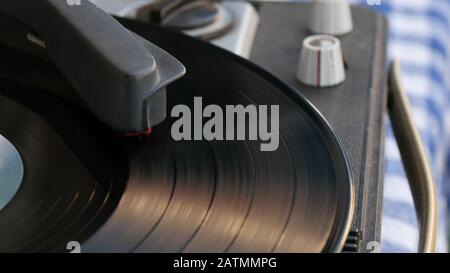 Vinyl-Schallplatte dreht sich. Nahaufnahme von Needle spielt Plattenalbum auf einem Vintage-Plattenspieler. Stockfoto