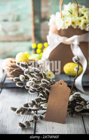 Ostereier auf Holz. Buntes Osterferienkonzept mit Eiern im Wisker Korb. Ostergrüßkarte Stockfoto