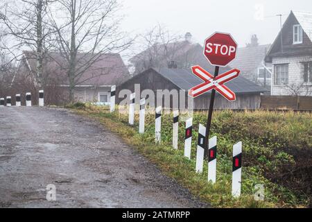 Leerer Landbahnübergang mit rotem Stoppschild Stockfoto