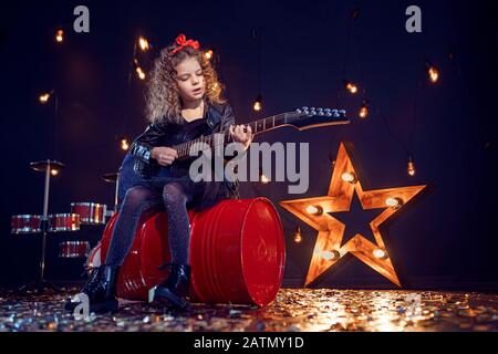 Junges attraktives Rockmädchen, das die E-Gitarre spielt. Stockfoto