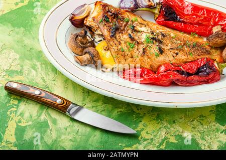 Roter Meerbarsch mit Pilzen und rotem Pfeffer gebacken.Fisch in geröstetem Gemüse.Gesunde Lebensmittel Stockfoto