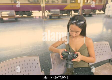 Junge, schöne Touristenfrau mit Kamera, die die Stadt erkundet Stockfoto