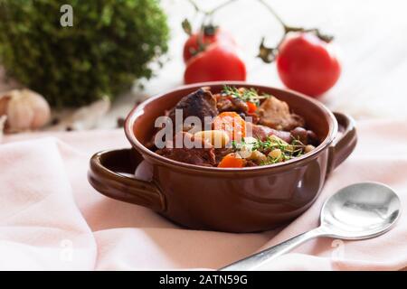 Cassoulet. Mit Fleisch Schweinefleischwürstchen, Gans, Ente und manchmal Hammel und zwei Arten von weißen Bohnen. Französische Küche. Auf altem weißen Holzhintergrund. Stockfoto