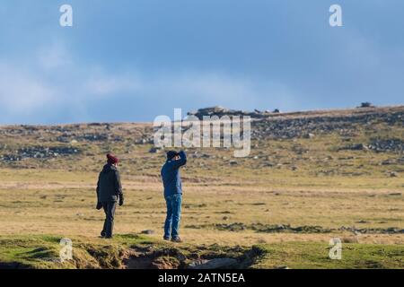 Wanderer, die sich auf den Gipfel des Rough Tor im Bodmin Moor in Cornwall vorbereiten. Stockfoto