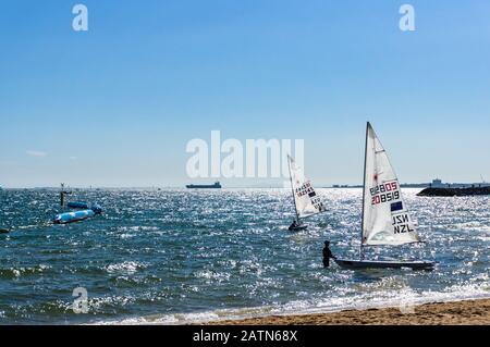 Melbourne, Australien - 7. Dezember 2016: Sportler, die Segelboote nach dem Wettkampf am St. Kilda-Strand pflegen Stockfoto