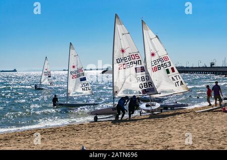 Melbourne, Australien - 7. Dezember 2016: Sportler, die Segelboote nach dem Wettkampf am St. Kilda-Strand pflegen Stockfoto