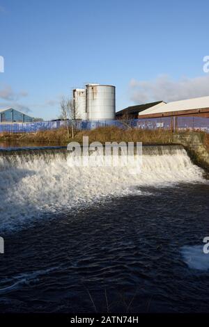 Wehr an der irwell mit Industriegebäuden und Silos in Der Hintergrund in radcliffe in Bury lancashire uk Stockfoto