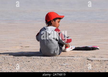 Als kleiner Junge im Alter von etwa 6 Jahren, der auf dem Stadtplatz in Essaouira, Marokko, Taschentücher an Touristen verkauft Stockfoto