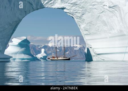 Das Segelschiff Donna Wood, das durch einen massiven Eisbogen in Scoresby Sound, Ostgrönland, gesehen wird Stockfoto