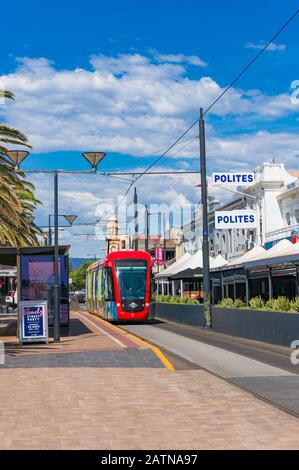 Glenelg, Australien - 13. November 2017: Leuchtend rote Straßenbahn auf den Straßen von Glenelg Toan, South Australia Stockfoto