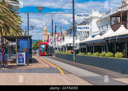 Glenelg, Australien - 13. November 2017: Leuchtend rote Straßenbahn auf den Straßen von Glenelg Toan, South Australia Stockfoto