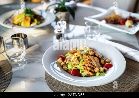 Ein köstlicher gegrillter oder gerösteter Hühnersalat wird in einem eleganten Restaurant oder Hotel serviert Stockfoto