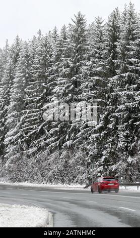 Einsiedel, Deutschland. Februar 2020. Ein Auto fährt auf einer Landstraße durch den verschneiten Wald bei Einsiedel. Kredit: Jan Woitas / dpa-Zentralbild / dpa / Alamy Live News Stockfoto